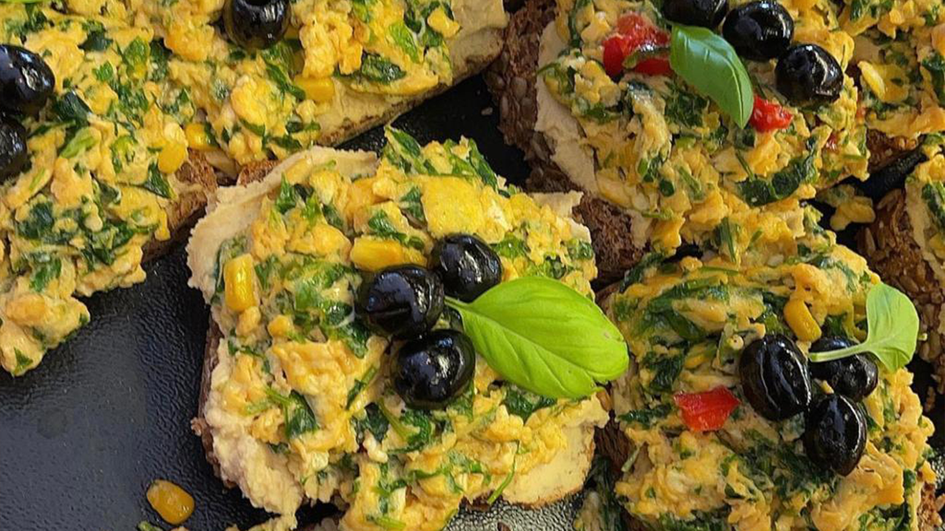 Rührei mit Spinat und Oliven auf Vollkornbrot